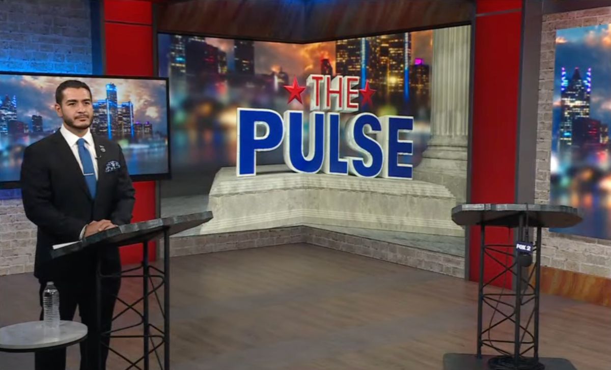 Abdul on the debate stage standing next to an empty podium